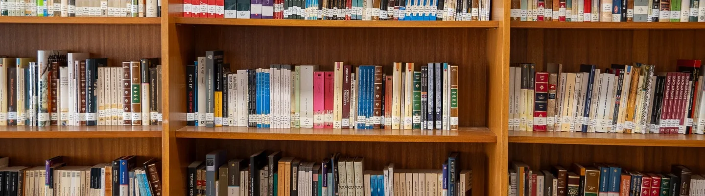 Estanterías con libros junto a sillas y mesas en una biblioteca