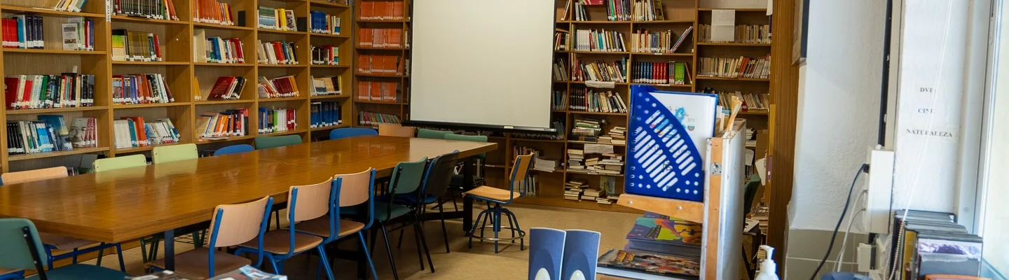 Estanterías con libros junto a sillas y mesas en una biblioteca