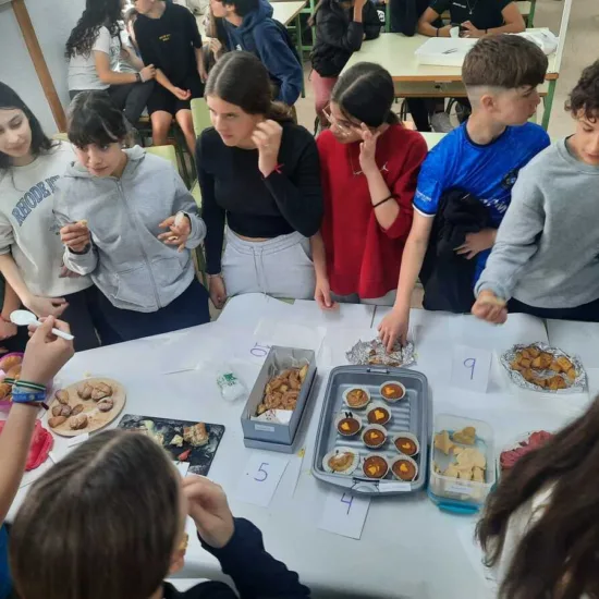 Alumnos conversando alrededor de una mesa con comida